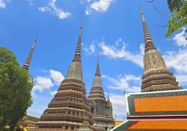 Wat Phra Chettuphon Wimon Mangkhalaram Ratchaworamahawihan ya da Wat Pho, Bangkok, Tayland 'da mavi gökyüzüne karşı süslü tapınak stupası grubu.,