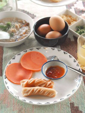 Sabah kahvaltı setini kapat. Sosis ve beyaz tabakta patates soslu carbonara..