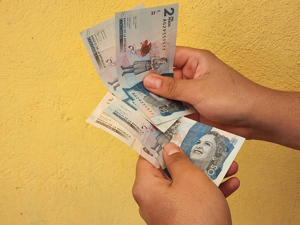 Mãos Homem Segurando Contando Notas Colombianas Fundo Amarelo — Fotografia de Stock