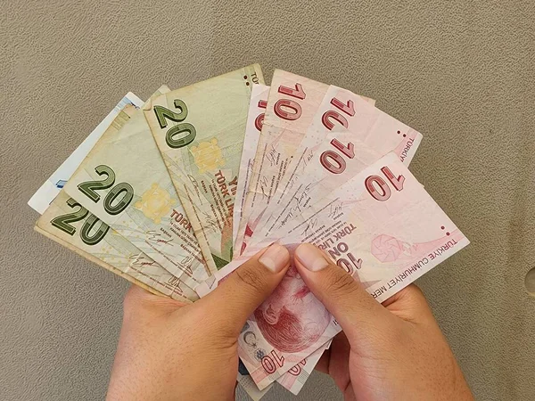 一个持有不同面额土耳其钞票的人的手 — 图库照片