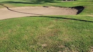 view of a golf course with fresh grass and sand trap