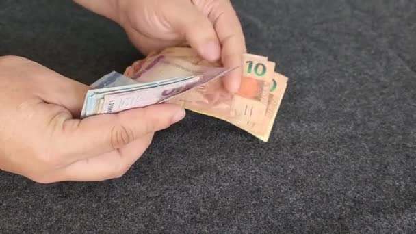 接近手拿着和数着巴西钞票的人的手 — 图库视频影像
