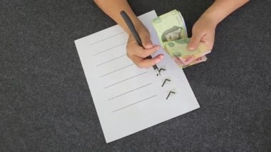 Meksika banknotlarını tutan ve sayan masanın üzerinde yapılacaklar listesi olan bir kadının elleri.