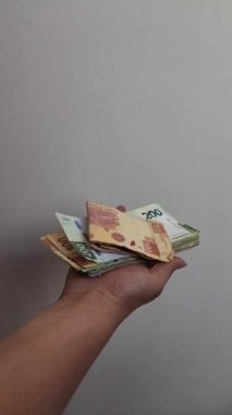 Meksika banknotları bir kadının elinden yavaş çekimde uçuyor.