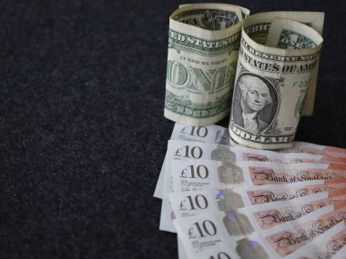 Yuvarlanan Amerikan banknotlarına ve sterlin banknotlarına yaklaşıyoruz.