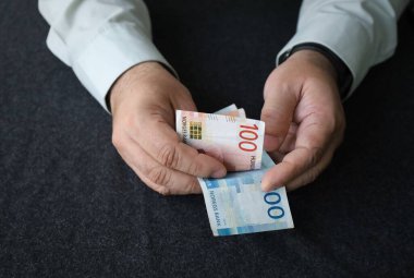 Norveç kronu banknotları tutan ve sayan bir adamın elleri