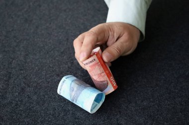 Masaya Norveç banknotları koyan bir adamın eli