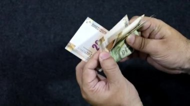 Peru banknotlarını tutan ve sayan bir adamın elleri
