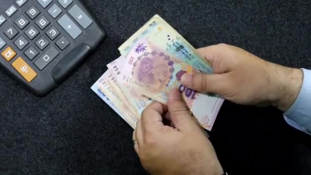 Egy Argentin Bankjegyeket Számláló Férfi Kezei Számológéppel Asztalon — Stock videók