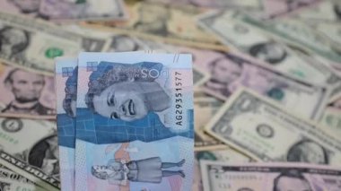 Kolombiya banknotları Amerika 'nın dolarlarıyla arka planı açıp bulanıklaştırıyor.