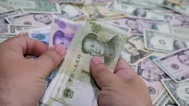 Ręce Liczące Chińskie Banknoty Rozmyte Tło Amerykańskimi Banknotami Dolarowymi — Wideo stockowe