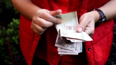 Farklı mezheplerden Türk banknotlarını tutan ve sayan bir kadının elleri