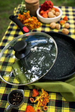 Farklı malzemelerle pişirme tavası ve masada yemek pişirmek için yemek.