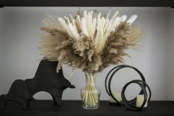 Beyaz duvarı, vazosu, vazosu, vazosu, ahşap rafı, siyah beyaz duvarı olan modern oturma odasının iç tasarımı. ev dekorasyonu.