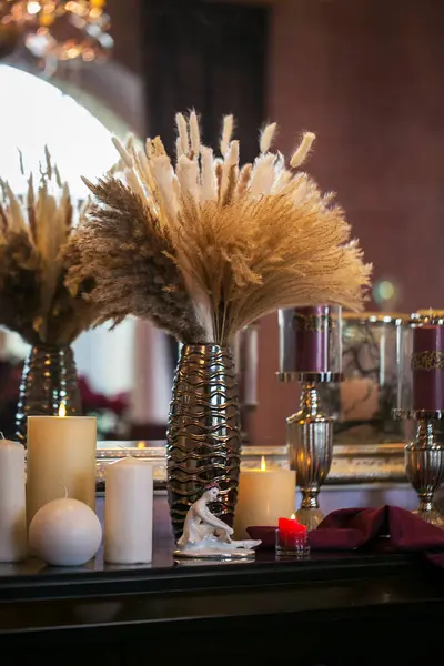 Mumlar ve mumlar vazonun içinde şöminenin önünde..