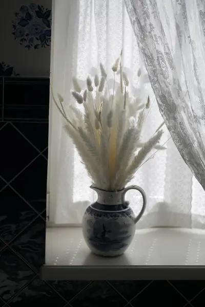 Vazodaki beyaz çiçekler pencere pervazında, kapat