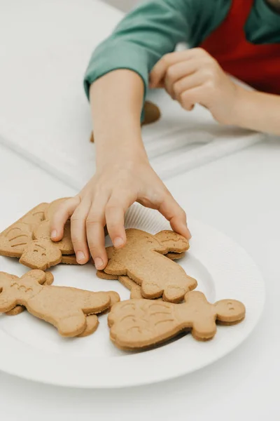 Een Kinderhand Reikt Naar Een Vers Gebakken Kerstkoekje Vorm Van — Stockfoto