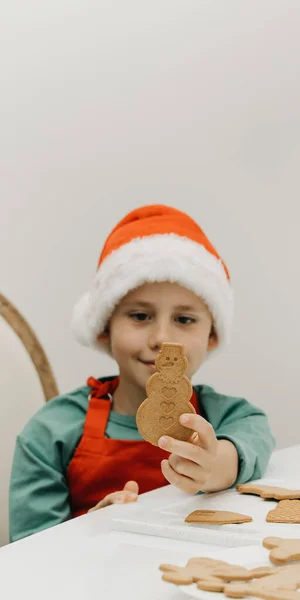 子供は雪だるまの形をしたジンジャーブレッドクッキーを持っています 年末年始 料理クリスマスクッキー — ストック写真