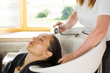 Kuaför müşterinin kafasını güzellik salonunun lavabosunda yıkar. Güzellik endüstrisi konsepti.