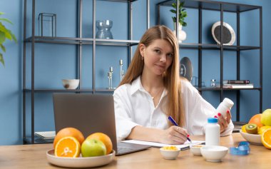 Beslenme uzmanı, çevrimiçi bir muayeneden sonra hastaya vitamin ve biyolojik olarak aktif maddeler için randevu yazar..