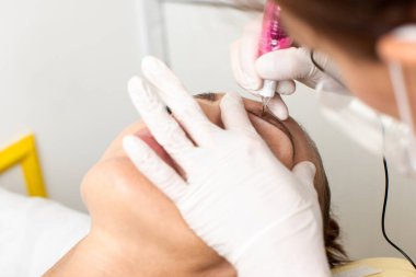 Güzellik salonunda kalıcı kaş makyajı süreci. Kalıcı dövme sanatçısı müşteri için kalıcı kaş makyajı yapar..