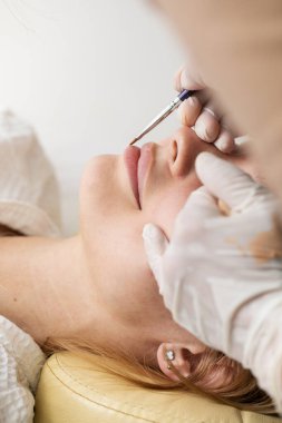 Usta, dudak daimi işleminden önce fırçayla bir eskiz çizer. Dudakların sınırlarını çizme süreci..