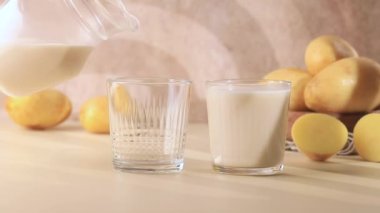 Patates sütü testiden bardağa dökülür. Süt ikamesi, vejetaryenler için süt. 