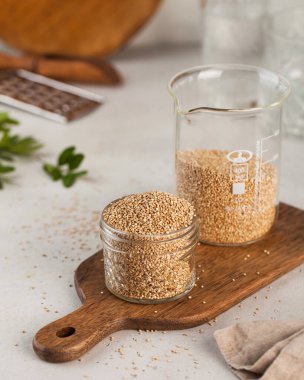 Cam kavanozlarda kurutulmuş kinoa taneleri ve masada tahta bir tahta. Süper yemek. Glütensiz ürünler.