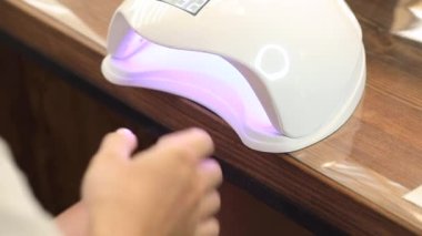  Shellac kaplamalı manikür. Ultraviyole lambayla kurutma işlemi. Yüksek kalite fotoğraf