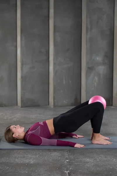 Atrakcyjna Kobieta Robi Pośladkowy Most Małą Różową Pilates Ball Koncepcja — Zdjęcie stockowe