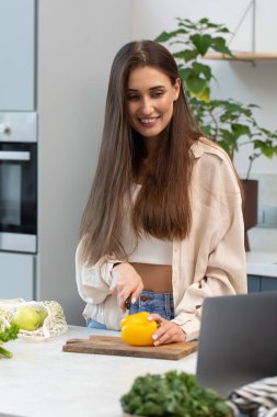 Çekici bir blogcu süreci canlı yayınlarken sebze salatası keser. Sağlıklı beslenme, video tarifine göre yemek pişirme, vejetaryenlik....