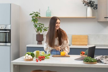 Çekici bir blogcu süreci canlı yayınlarken sebze salatası keser. Sağlıklı beslenme, video tarifine göre yemek pişirme, vejetaryenlik....