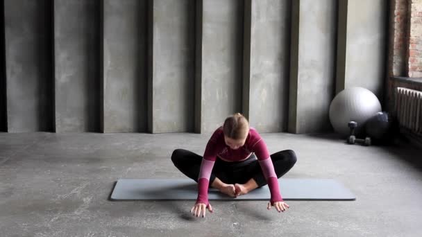 一个穿着运动服的女人练瑜伽 普拉提在垫子上 伸展的概念 瑜伽课 妇女体育 — 图库视频影像