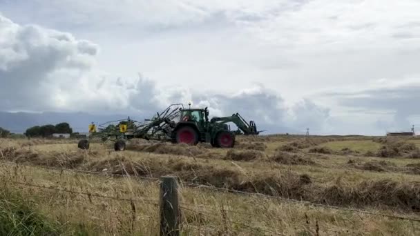 트랙터는 건초를 모으는 밭에서 기계의 — 비디오