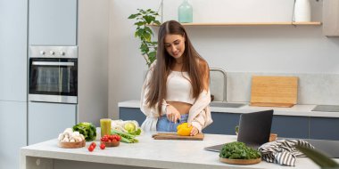 Çekici bir blogcu süreci canlı yayınlarken sebze salatası keser. Sağlıklı beslenme, video tarifine göre yemek pişirme, vejetaryenlik....