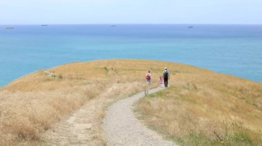 Yeni Zelanda 'da okyanus boyunca yürüyüş yapan bir aile. Yerel seyahat kavramı. Çarpıcı manzaralı bir yürüyüş yolu.. 