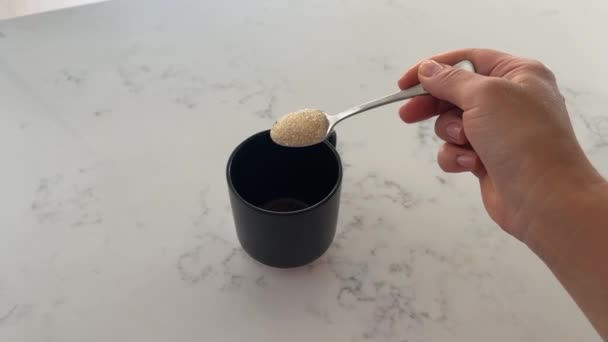 Uma Colher Chá Açúcar Mascavo Adoçante Derramada Uma Caneca Preta — Vídeo de Stock