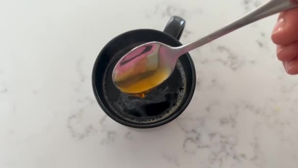 Een Theelepel Geroerde Zwarte Koffie Een Mok Tafel Bovenaanzicht Trage — Stockvideo