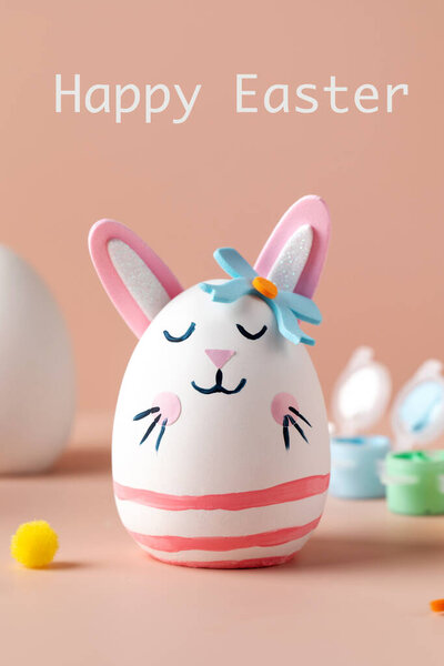 A greeting card with an egg in the form of a rabbit and the inscription Happy Easter. Ideas of Easter crafts with your own hands with children.