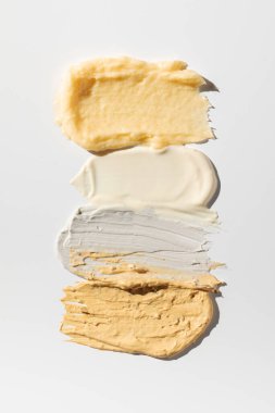 Beyaz arka planda deri ve saç bakımı için çeşitli kozmetik ürünlerinden örnekler ve dokular. Örnekler. Cilt bakımı.