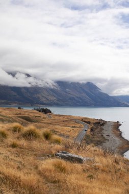 Bir dağ gölü, yol ve dağların manzarası. Yerel seyahat kavramı, kamp. Yeni Zelanda 'nın güney adasının güzel manzarası.