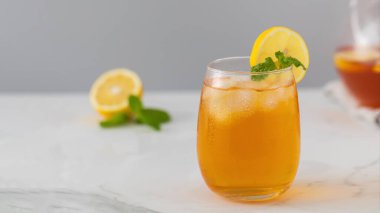 Bir bardak soğuk çay, buz küpleri, limon dilimleri ve bir tutam nane. Serinletici yaz içkileri..