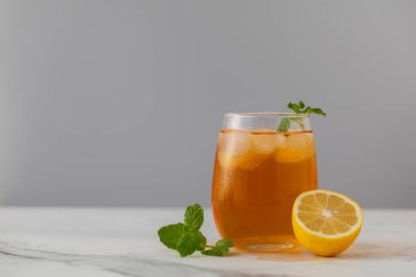 Bir bardak soğuk çay, buz küpleri, limon dilimleri ve bir tutam nane. Yaz içkilerinin soğutma konsepti. Boşluğu kopyala