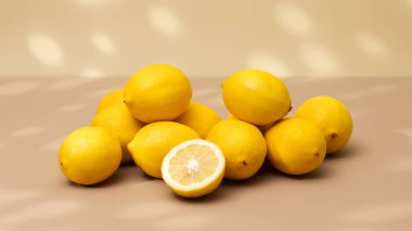 Bej arka planda bir avuç sarı olgun limon ve gölge deseni. Sulu limonlar.