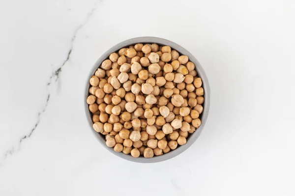 薄い背景にボウルに生のひよこ豆 植物性タンパク質の概念 菜食主義 — ストック写真