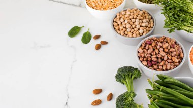 Baklagiller, brokoli, boş bir arkaplanda badem. Sebze proteini konsepti. Vejetaryenlik, sağlıklı beslenme..