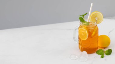 Bir bardak soğuk çay, buz küpleri, limon dilimleri ve bir tutam nane. Yaz içkilerinin soğutma konsepti. Boşluğu kopyala