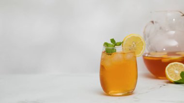 Bir bardak soğuk çay, buz küpleri, limon dilimleri ve bir tutam nane. Yaz içkilerinin soğutma konsepti. Boşluğu kopyala