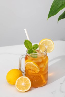 Bir bardak soğuk çay, buz küpleri, limon dilimleri ve bir tutam nane. Serinletici yaz içkileri..