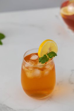 Bir bardak soğuk çay, buz küpleri, limon dilimleri ve bir tutam nane. Serinletici yaz içkileri..